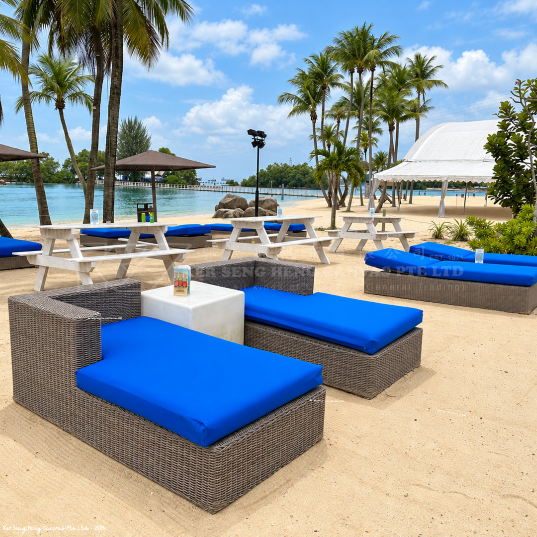 Custom-made blue outdoor lounge cushions fitted on wicker daybeds at a beachfront resort, designed for comfortable outdoor seating and relaxation. KSH Canvas.